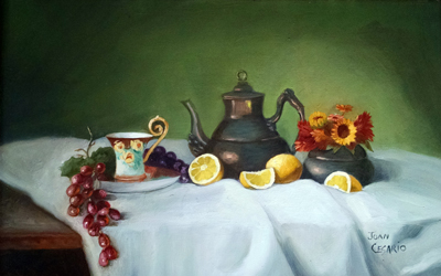 Teapot and teacup with lemons and grapes.
